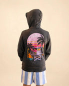 Child wearing The Evening Palm Kids Hoodie in dark heather grey with Palmr logo and sunset graphic