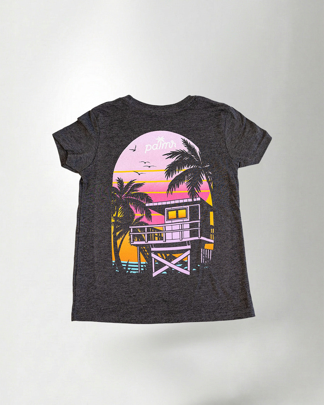 Child wearing a black t-shirt with a colorful graphic design on the back, standing against a plain background.