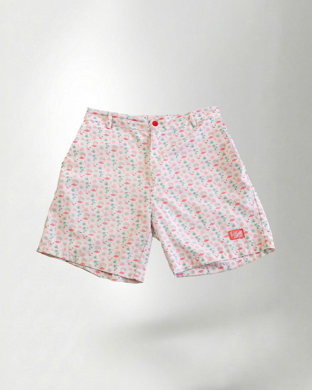 Pink floral shorts and white sneakers on a plain background