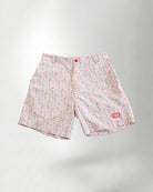 Pink floral shorts and white sneakers on a plain background