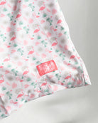 Pink floral shorts and white sneakers on a plain background