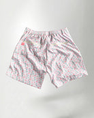 Pink floral shorts and white sneakers on a plain background