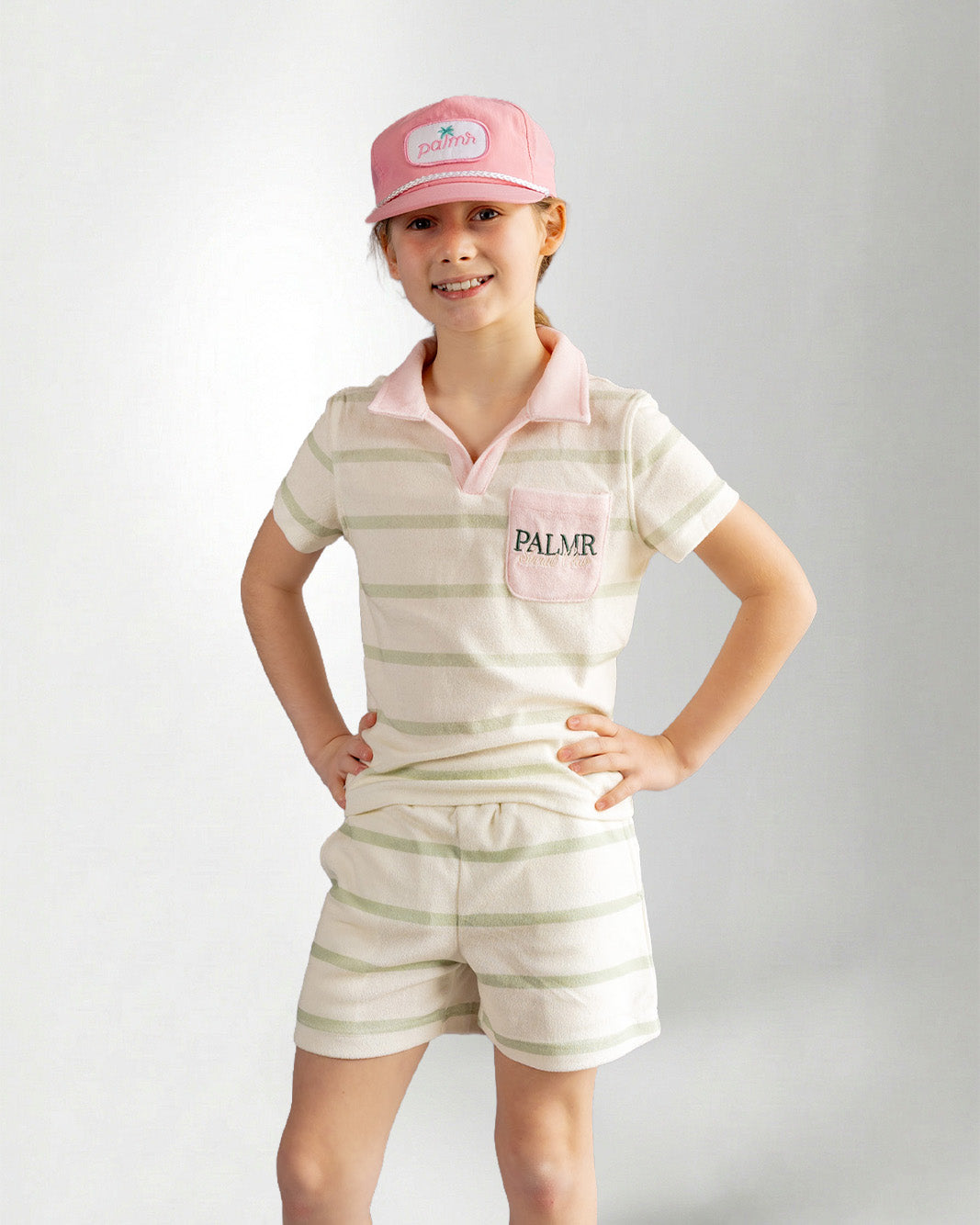 Girl wearing green striped shorts and top with palmr branding 