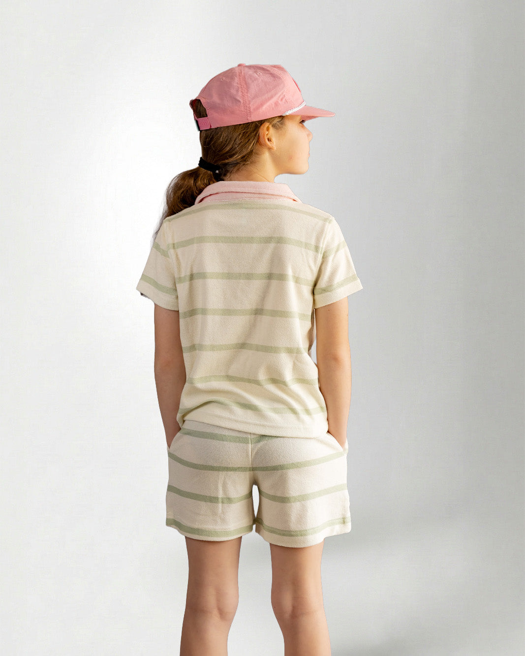 Girl wearing green striped shorts and shirt with palmr branding 
