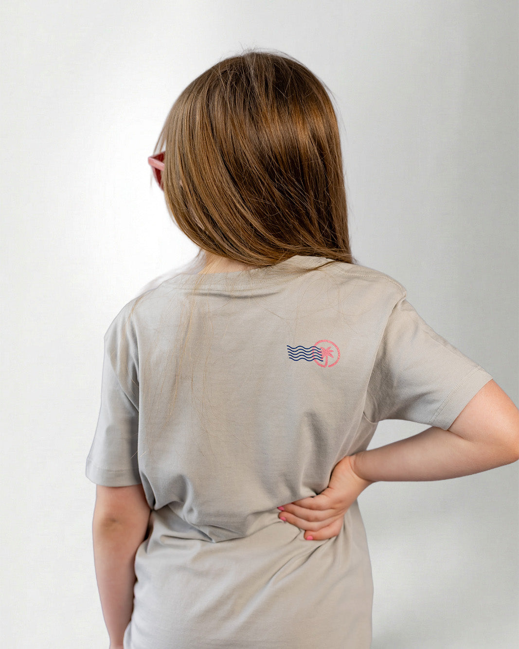 Person wearing a light gray t-shirt with stamp on the back