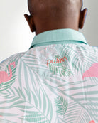 Person wearing a shirt with palm tree and flamingo pattern, brand 'palms' visible.