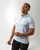 Man wearing a patterned shirt and pants against a plain background
