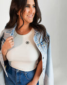 Denim jacket with a colorful parrot design on the back, worn by a person.