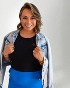 Denim jacket with a colorful parrot design on the back, worn by a person.