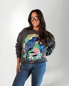 Woman wearing a sweatshirt with a colorful parrot design on a plain background