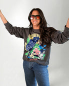Woman wearing a sweatshirt with a colorful parrot design on a plain background