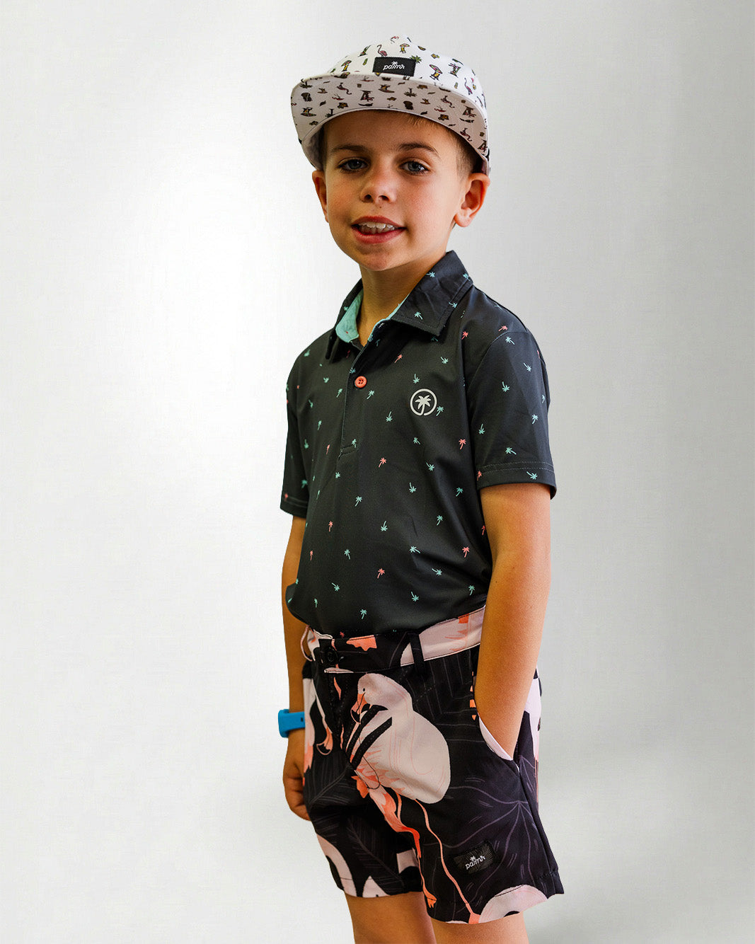 Person wearing a black patterned shirt and shorts with a white bird design on a plain background