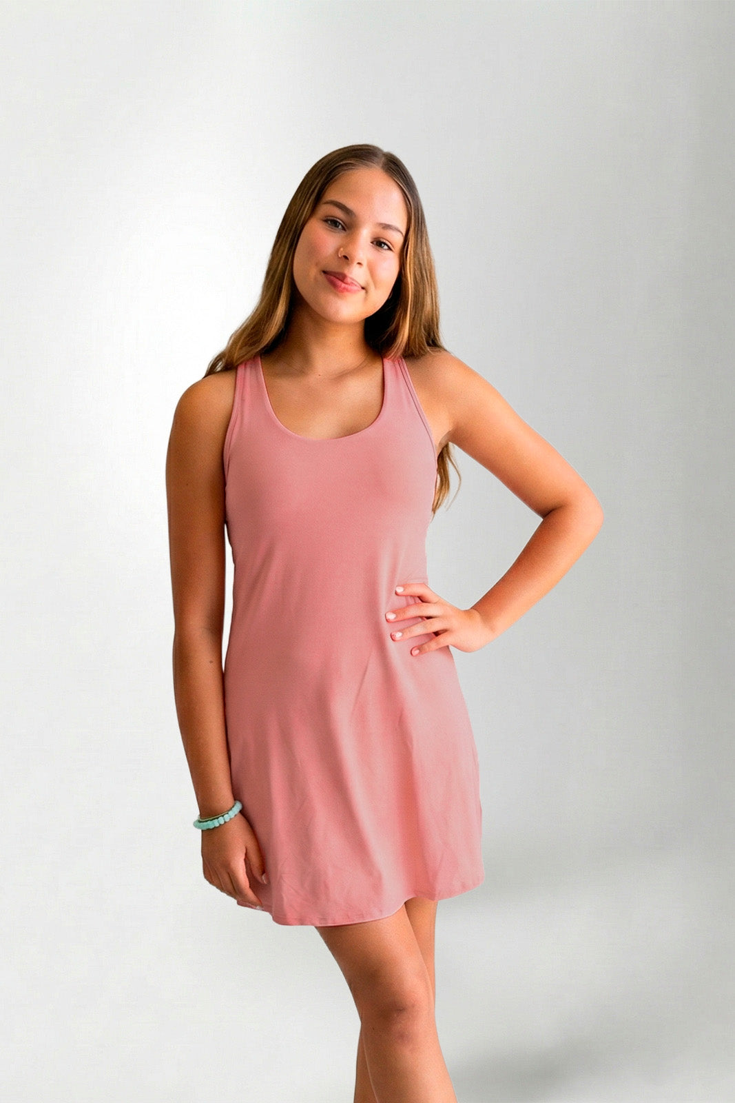 Woman wearing a pink dress against a plain background