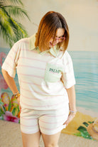 Woman wearing a pastel-colored outfit with a 'Palm' logo, standing against a colorful background.