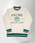 A cream-colored sweatshirt with 'Palmr Social Club' branding on a light gray background