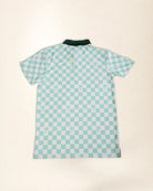 A short-sleeve polo shirt with a mint green and white checkerboard pattern, featuring small palm tree motifs on the squares and a solid dark green collar, laid flat against a light beige background.