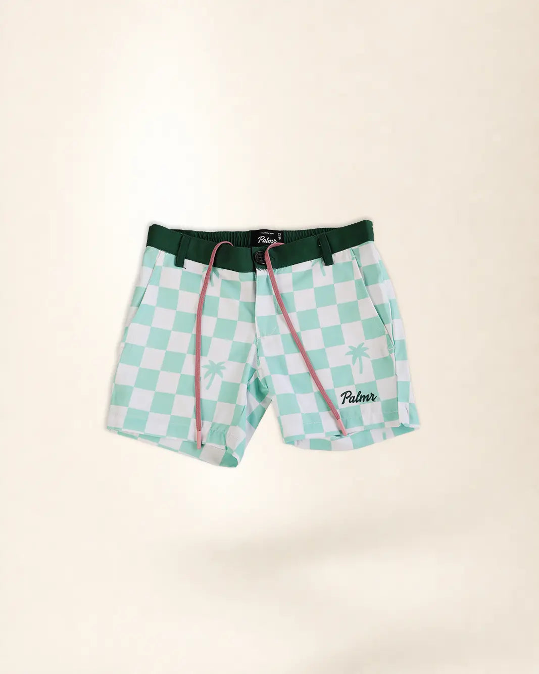 A pair of kid's swim trunks featuring a mint green and white checkered pattern, a dark green waistband, and pink drawstrings. The brand name 'Palmer' is embroidered in black script on the lower right leg.