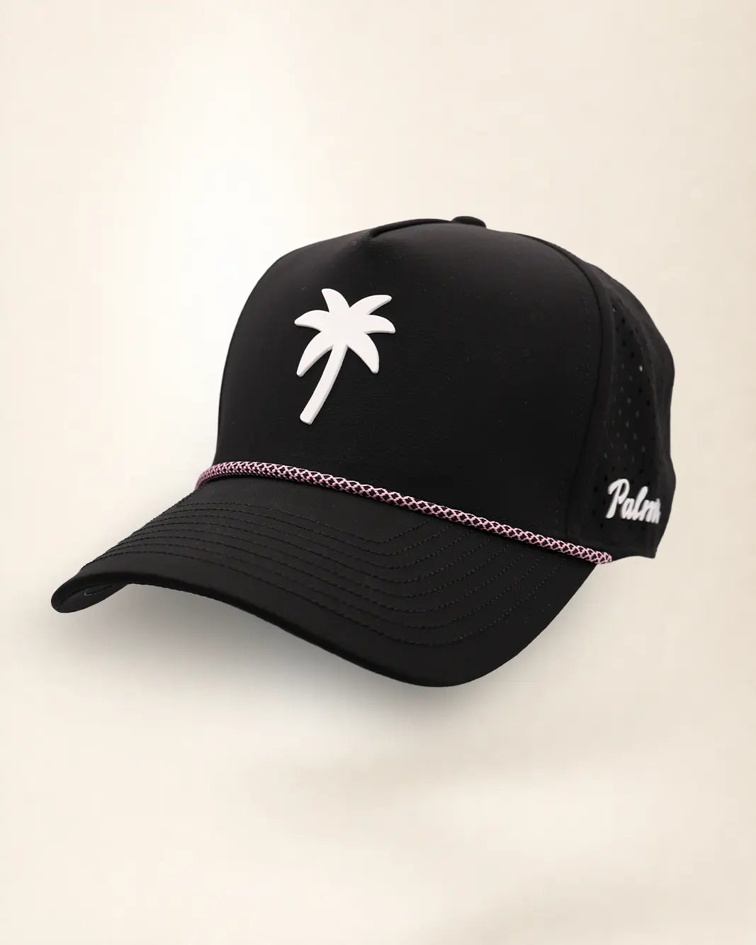 The Palm Icon Signature Hat (Black), three-quarter view: white raised palm tree icon on a black rope snapback, pink and white rope, white Palmr script.