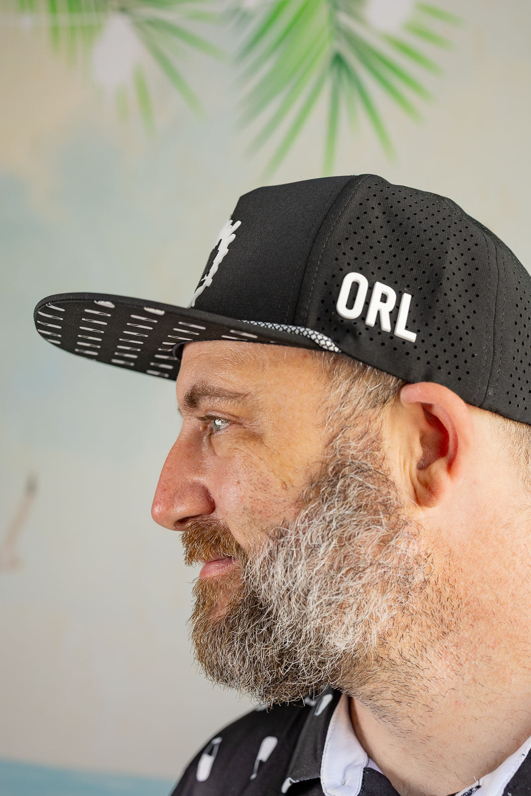 Man wearing a black cap with 'ORL' on it, against a blurred outdoor background.