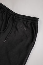 Black sweatpants with 'Palmr' embroidery on a light gray background