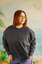 Person wearing a dark gray sweatshirt with 'Palmer' text, standing against a colorful mural background.