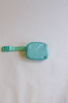 Turquoise waist bag on a light gray background