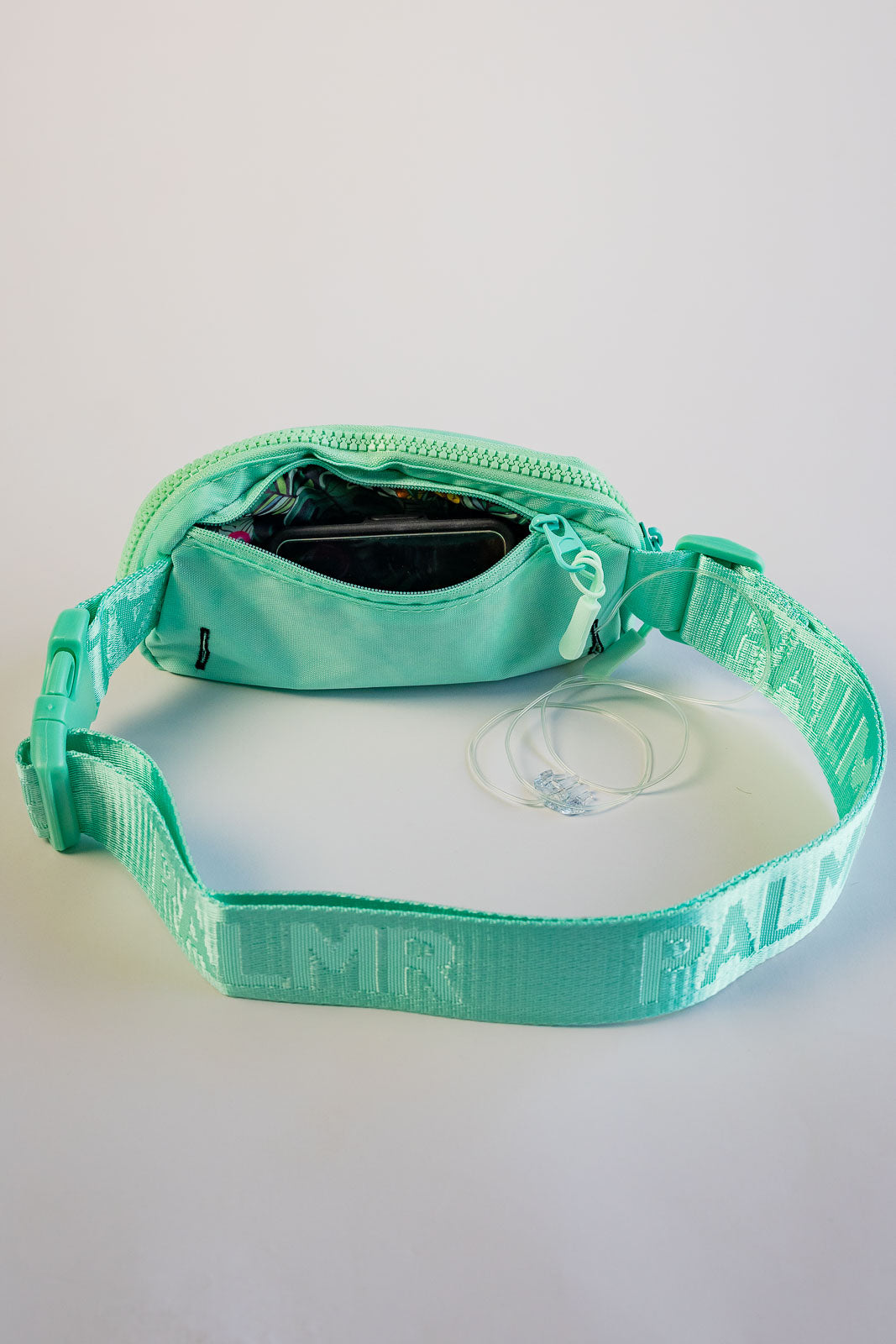 Turquoise dog collar with visible branding on a light gray background