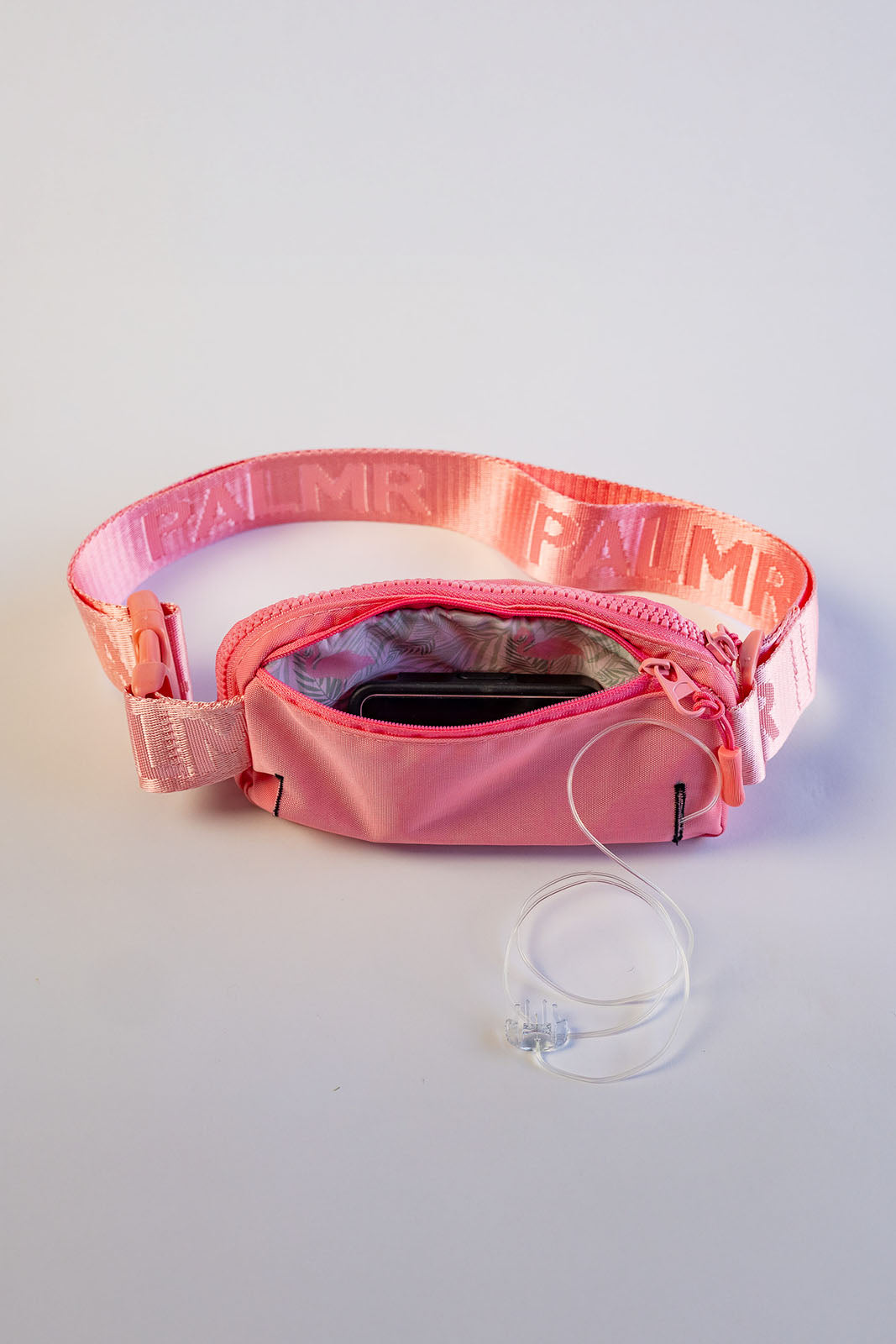Pink waist bag with a clear strap on a light gray background