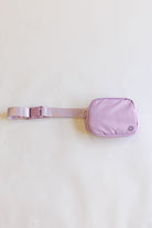 Purple waist bag with a belt on a white background
