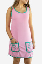 Pink dress with green trim and floral designs on a white background