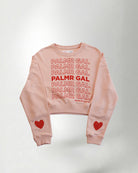 Peach sweatshirt with 'PALMR GAL' text and heart designs on a plain background