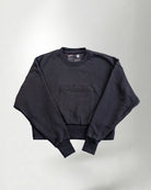 Sweatshirt with 'PALMR' branding, holding a floral-patterned bag against a white background.