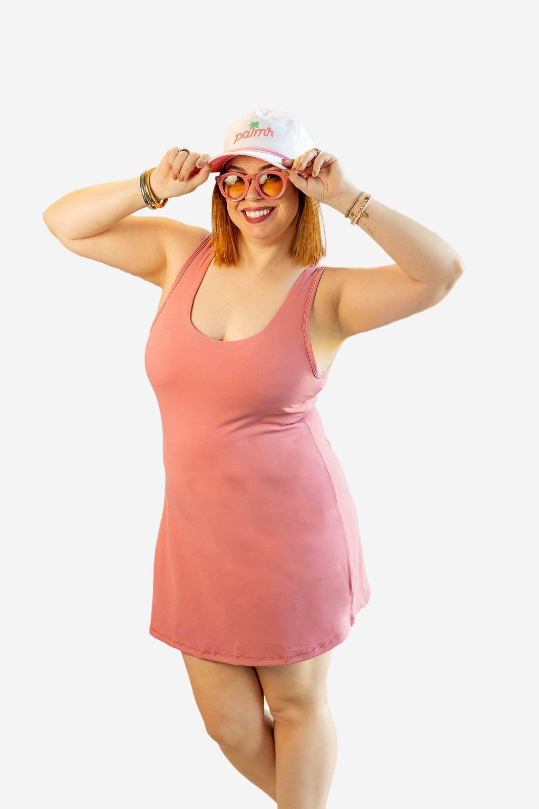 Woman wearing a pink dress and white cap with red text on a white background
