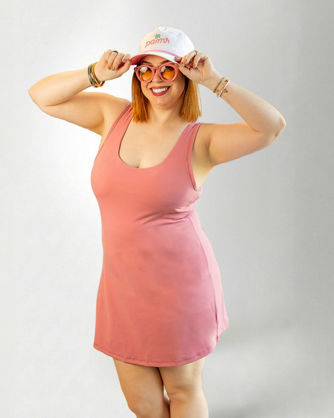 Woman wearing a pink dress against a plain background