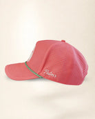 A pink perforated baseball cap with a green and white patterned trim along the brim and white 'Palmr' script embroidery on the side, shown against a light beige background.