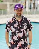Man wearing the Purple and gold The 407 Hat with white Orlando area code and small palm logo on side