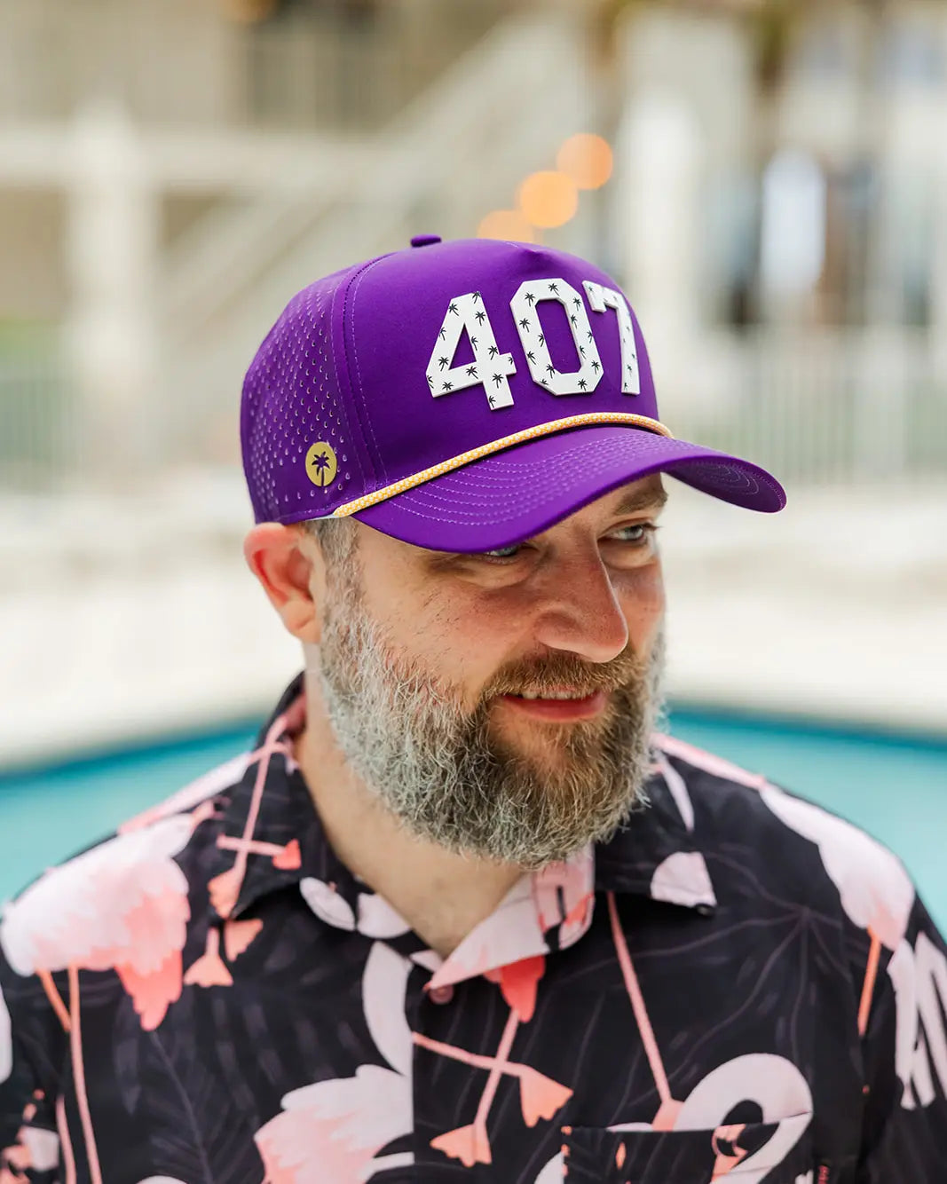 Man wearing the Purple and gold The 407 Hat with white Orlando area code and small palm logo on side