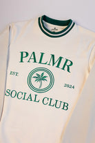 White sleeveless shirt with green text and palm tree design on a white background