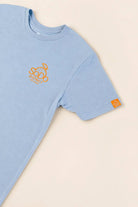 Blue SoDo Neighborhood Tee with orange logo and neighborhood icons promoting local pride and community support