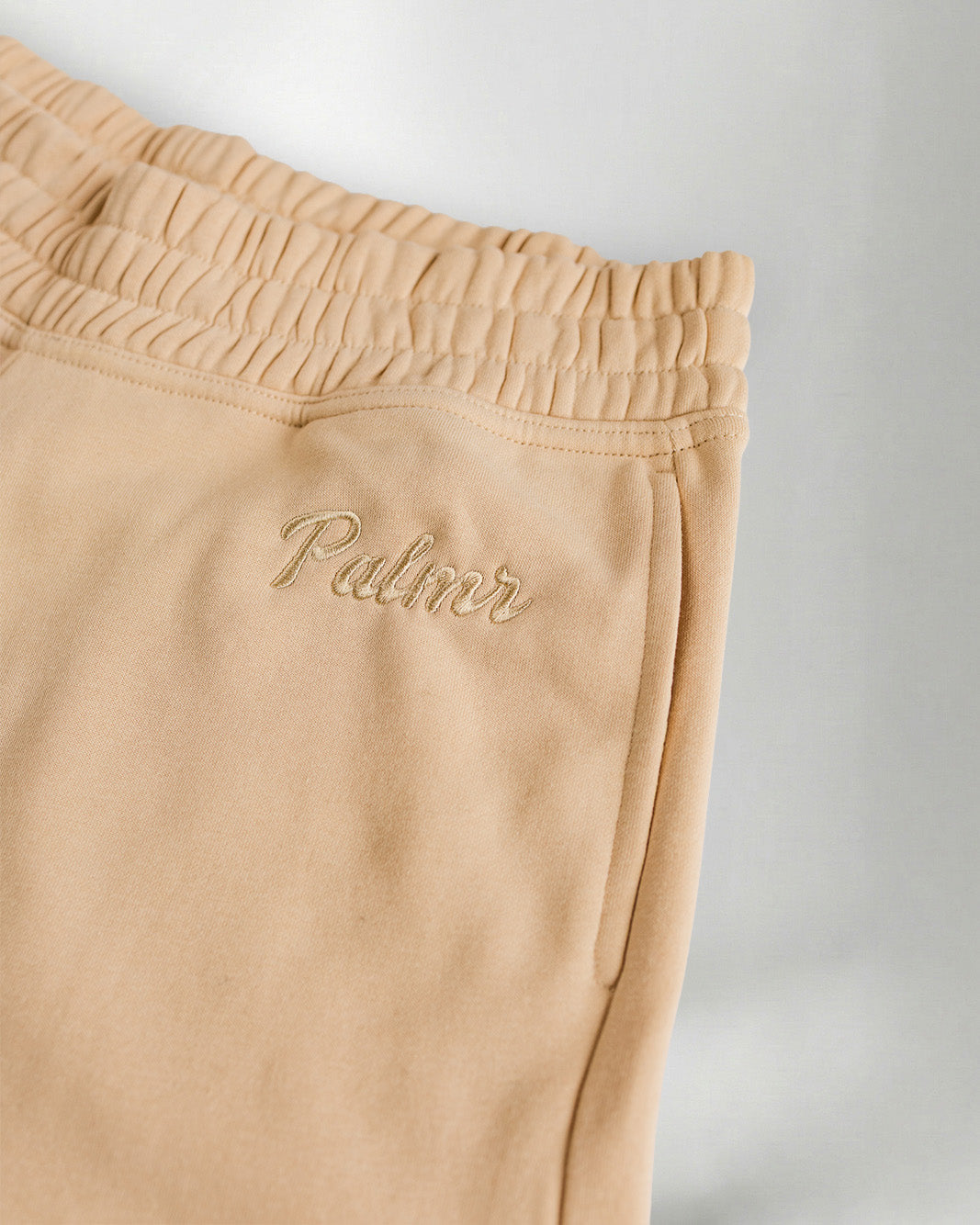 Light Beige "Palmr" shorts over a gray background