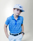 Child wearing a blue patterned polo shirt and cap with a white background