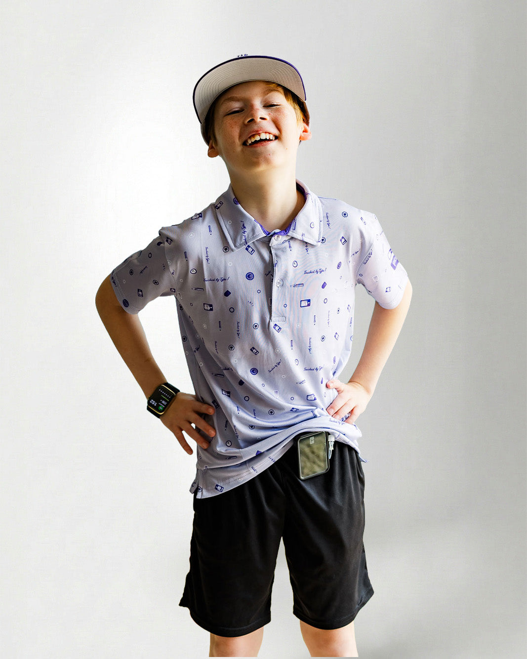Child wearing a patterned polo shirt and cap on a plain background