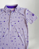 Child wearing a patterned polo shirt and cap on a plain background