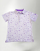 Woman wearing a patterned shirt and jeans against a plain background