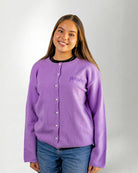 Woman wearing a Purple "Touched by Type 1" cardigan against gray background.