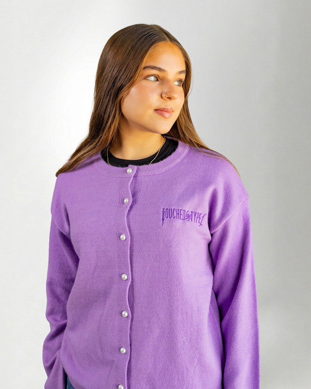 Woman wearing a Purple "Touched by Type 1" cardigan against gray background.