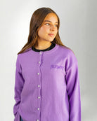 Woman wearing a Purple "Touched by Type 1" cardigan against gray background.