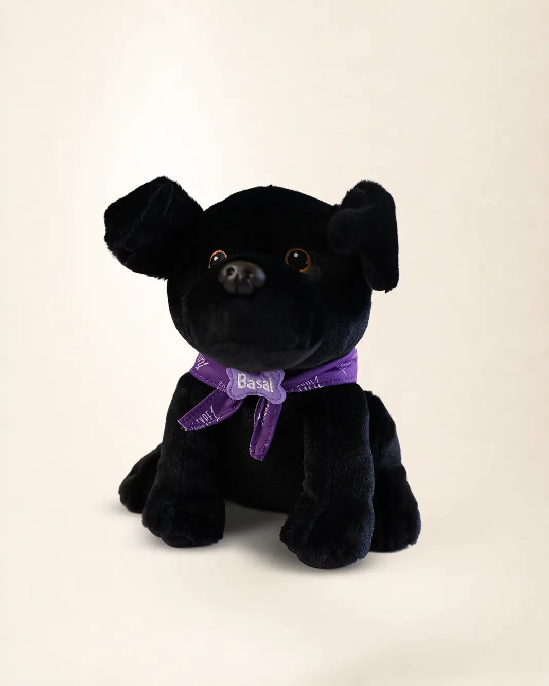 Basal Dog Plush, a black Labrador plush wearing a purple Touched By Type 1 bandana and a Basal name tag