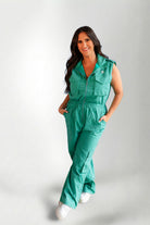 Woman wearing a green jumpsuit on a gray background