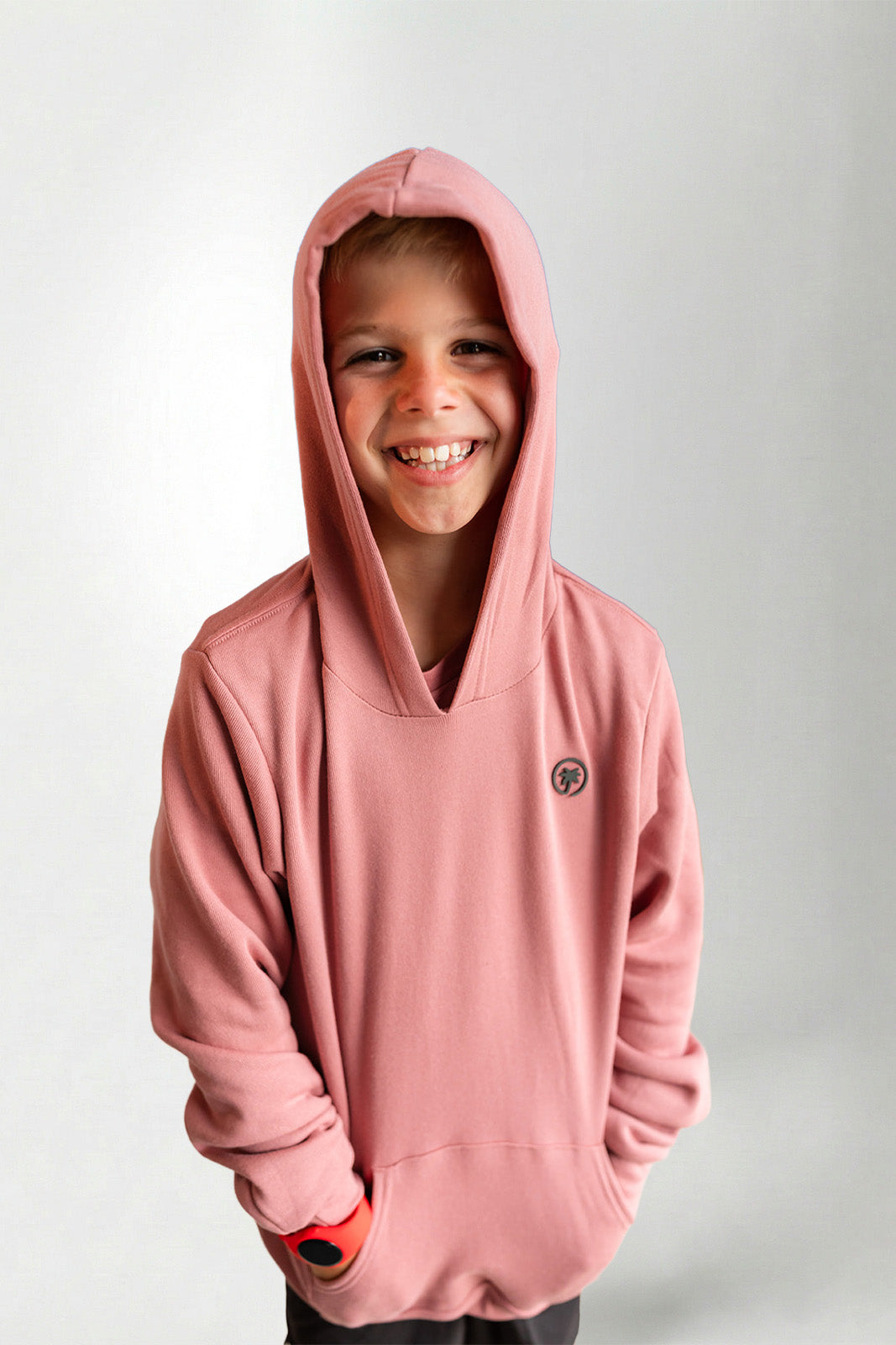 Child wearing a pink hoodie with a small logo on a light gray background
